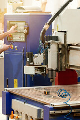 A worker sets up an automatic milling machine