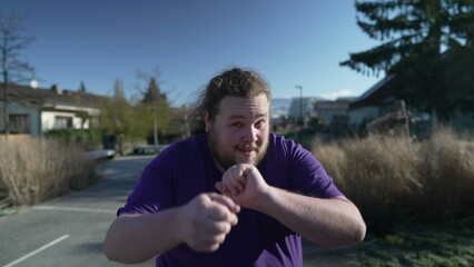 A fat relaxed man dances happily in the street. One funny overweight person dancing outdoors....