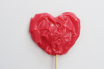 Red melted lollipop close-up on a white background.