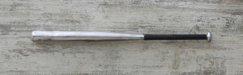 metal baseball bat on white wooden background