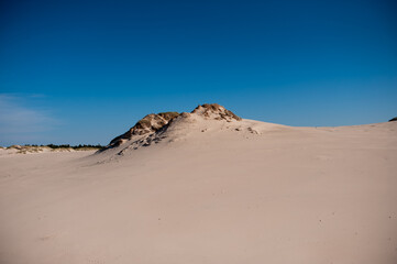 Fototapeta na wymiar dunes in the desert against the blue sky