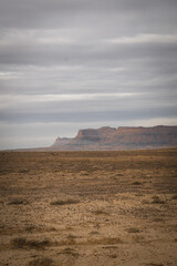Green River Utah desert landscape in winter with dry grasslands and brown buttes and mesas in background