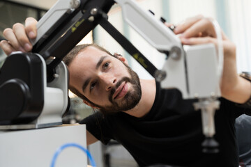 Male engineer training or maintenance AI robot in the manufacturing automation and robotics...