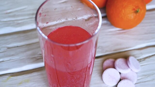 Top view. Throw a vitamin C into a glass of water. The concept of drinking vitamin c in tablets. Close-up fruit juice or freshly squeezed. Medicinal fruit tablets against beriberi