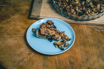 A piece of sweet cake with nuts, apples on a blue plate