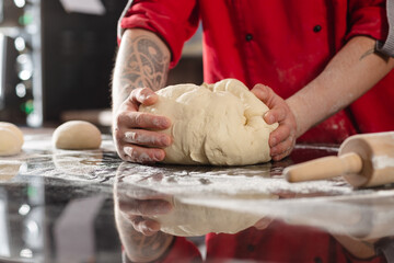 pizzaiolo prepares pizza in the kitchen, the chef prepares the dough