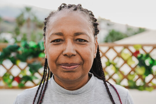 Senior african woman smiling on camera at home patio