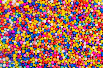 Bright background of scattered multicolored round candies, dragees. Sugar candies. A fun holiday....
