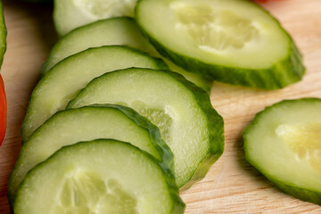 Sliced green long cucumber during salad preparation