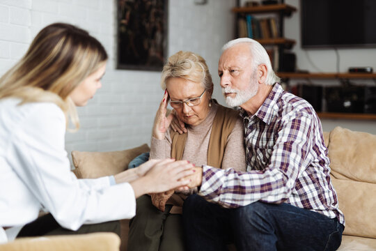 Senior couple talking with their caregiver at home