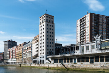 Fototapeta na wymiar Traditional residential buildings and skyscraper of Bailen in the riverside of Nervion River in the Old Quarter of Bilbao