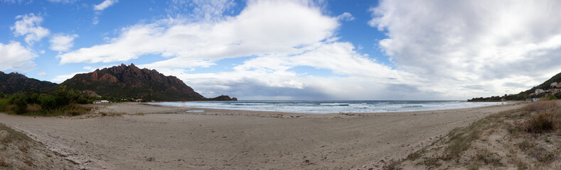 Sandy Beach at a Town on the Sea Coast. Foxi Manna, Sardinia, Italy. Mountain Background. Panorama