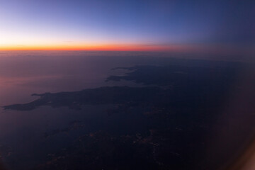 Amazing sky view from airplane porthole to sunset sky with European continent, Spain.