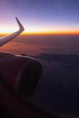 Amazing night sky after sunset from a porthole with a wing and a turbine. Travel by air plane, concept.