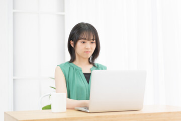 ノートパソコンを使っている若い女性