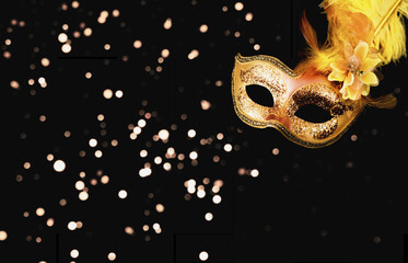 Golden Carnival mask on dark background with sparkles. Mardi Gras concept or New Years decoration....