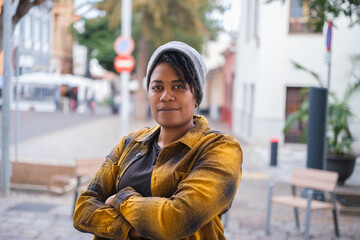 Fototapeta premium Portrait of young woman with dreadlocks and urban style type hat outdoors in the city streets. Concept: hairstyle, urban style, lifestyle
