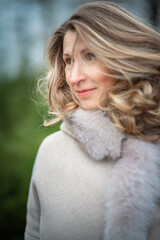 Portrait of a young beautiful fair-haired girl in a winter fur coat.