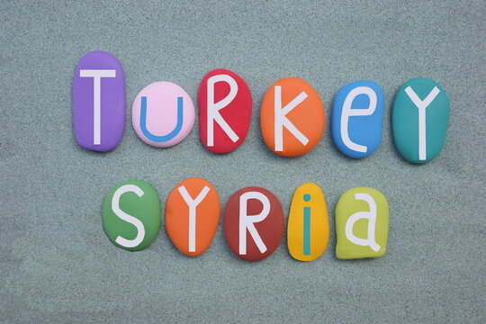Turkey, Syria, country names composed with multi colored stone letters over green sand