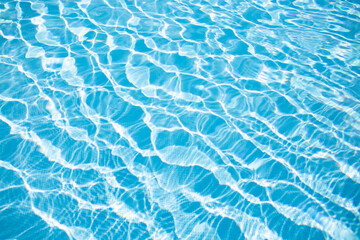 Amazing beautiful blue water texture with waves in the pool