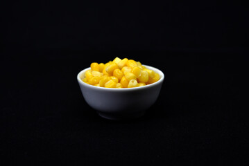 Fresh canned corn. Corn kernels in a white salad bowl. Corn in a cup.