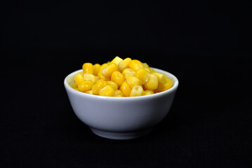 Fresh canned corn. Corn kernels in a white salad bowl. Corn in a cup.