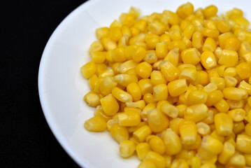 Fresh canned corn on a white plate. Corn salad. Yellow corn kernels.