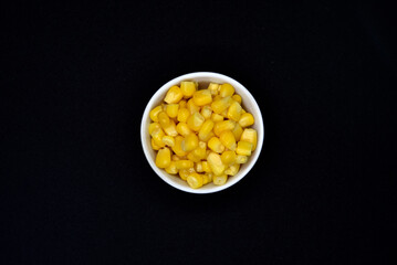 Fresh canned corn. Corn kernels in a white salad bowl. Corn in a cup.