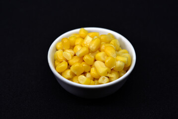 Fresh canned corn. Corn kernels in a white salad bowl. Corn in a cup.