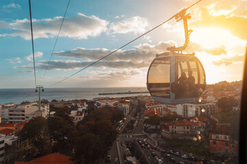 Beautiful city of Funchal with houses, funicular cable car, ocean and amazing sunset. Journey to Madeira Island. Travel - obrazy, fototapety, plakaty
