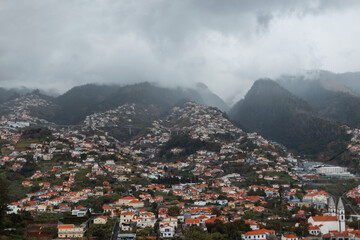 Fototapeta na wymiar Beautiful mountain landscape with clouds and houses on the island of Madeira