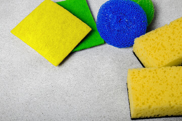 multi-colored different tipes of dishwashing sponges and napkins on grey background. The topic of...