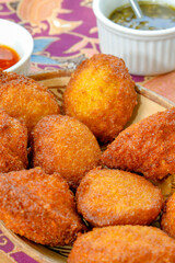 Brazilian food: acarajé with vatapá, sauce and pepper on a colorful table. Typical dish from Bahia, Brazil