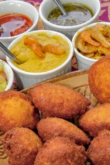 Brazilian food: acarajé with vatapá, sauce and pepper on a colorful table. Typical dish from Bahia, Brazil