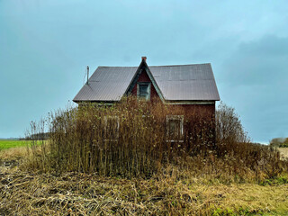 An abandoned house across a field.