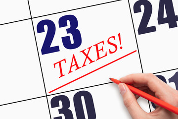 23rd day of the month. Hand writing text TAXES and drawing a line on calendar date.