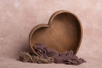 background texture empty space for baby with wooden heart and mattress. basket for a newborn photo shoot. heart made of wood, decorated with cute plush toys