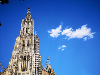 Fototapeta na wymiar Ulmer Münster im Sommer mit strahlend blauem Himmel und Fachwerkhaus in der Altstadt
