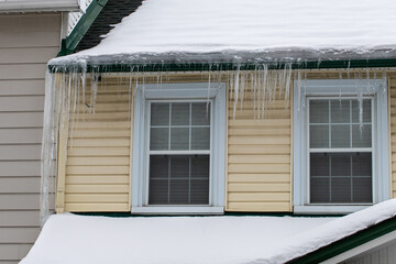 Icicles hanging on a house roof in winter