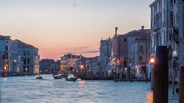 Grand canal with gondolas near Rialto Market day to night transition timelapse after sunset, San Polo, Venice, Italy viewed from pier at summer