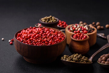 Composition, concept, consisting of several types of different colors of allspice in bowls and spoons