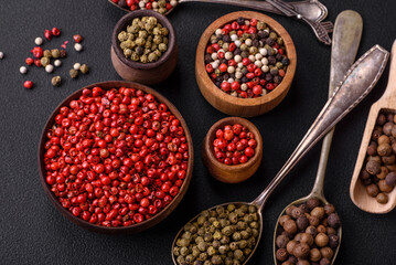 Composition, concept, consisting of several types of different colors of allspice in bowls and spoons