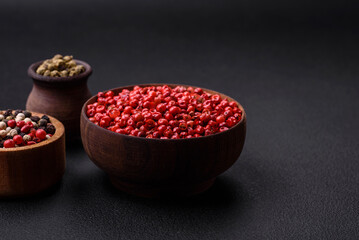 Composition, concept, consisting of several types of different colors of allspice in bowls and spoons