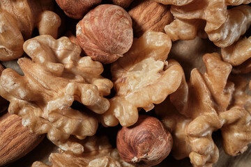 Background from a mixture of nuts of almonds, hazelnuts and walnuts. Close-up. Top view. Space for lettering and design.