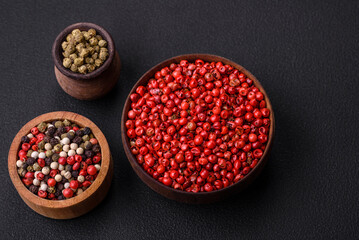 Composition, concept, consisting of several types of different colors of allspice in bowls and spoons