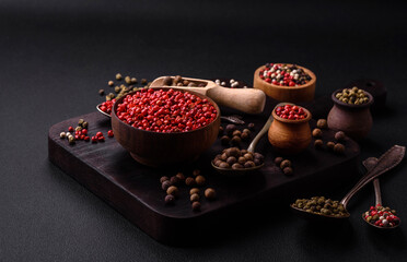 Composition, concept, consisting of several types of different colors of allspice in bowls and spoons