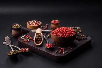 Composition, concept, consisting of several types of different colors of allspice in bowls and spoons