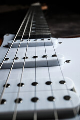 Close-up of a fragment of the pickups and strings of an electric guitar. Selective focus.