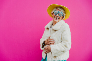 Happy grandmother posing on colored backgrounds