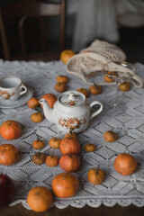 Fototapeta na wymiar Tangerine on the table. Cups and pot on the table